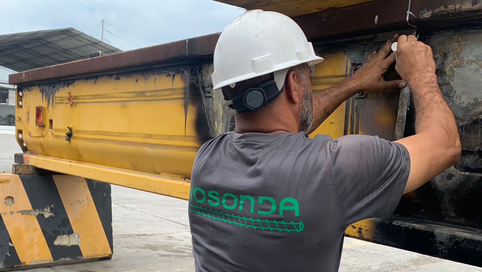 Biosonda technician performing corrective maintenance on a drilling rig at a construction site